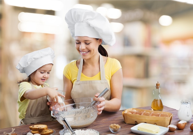 Ritratto di una bambina adorabile e di sua madre che cucinano insieme