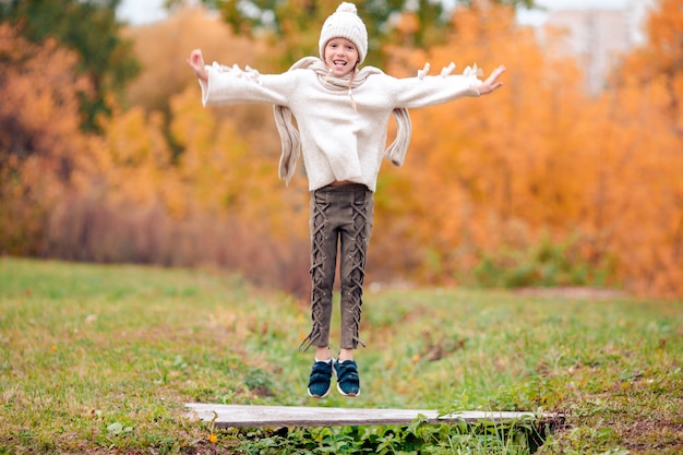 Portrait of adorable little girl outdoors at beautiful autumn day