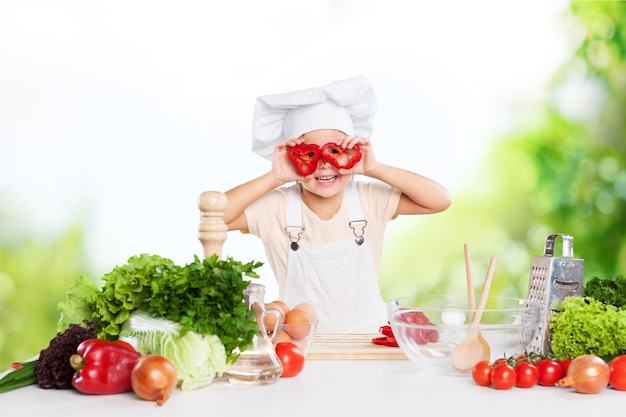 Портрет очаровательной маленькой девочки, готовящей здоровую пищу на кухне