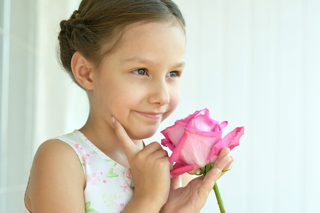バラの花を持つ愛らしい少女の肖像画