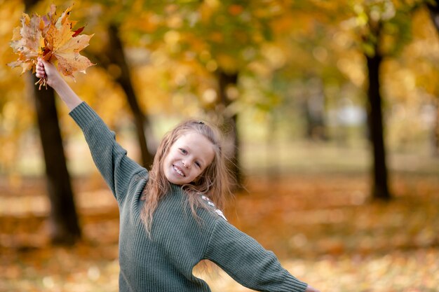 노란 사랑스러운 작은 소녀의 초상화 가을 꽃다발 나뭇잎