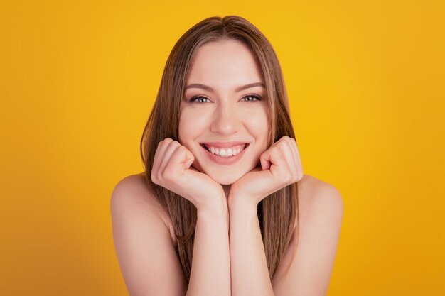 Portrait of adorable nice stunning pretty dream lady fists chin beaming white smile on yellow background