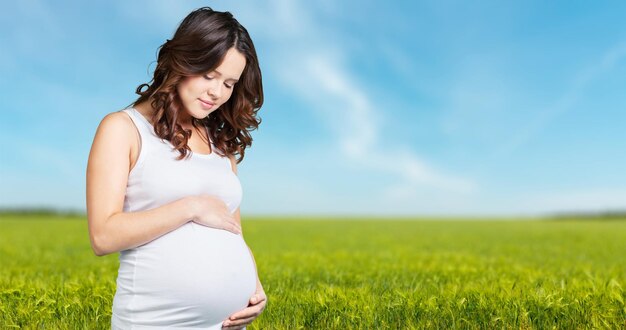 Portrait of adorable pregnant woman in white