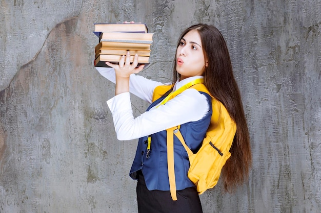 Portrait of adorable student with backpack holding books. High quality photo