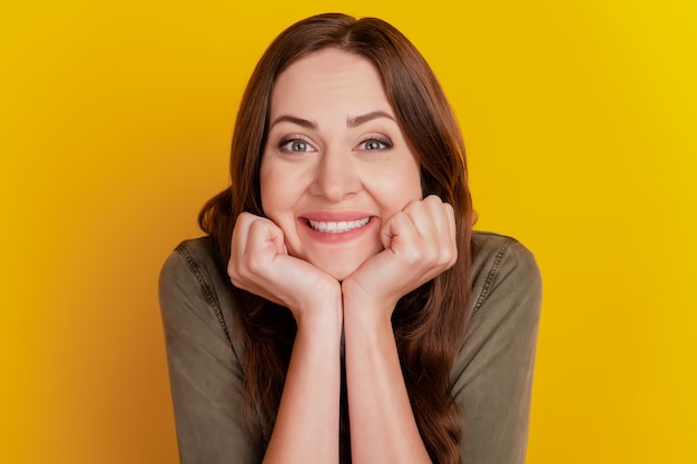 Portrait of adorable sweet girl hands cheeks toothy smile on yellow background