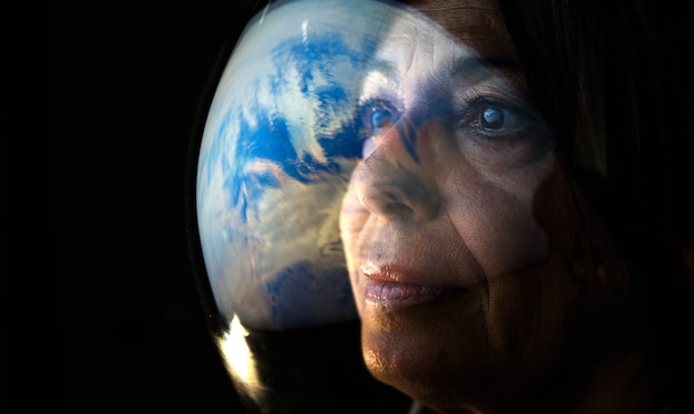 행성 지구를 보고 있는 성인 여성 우주 비행사의 초상화