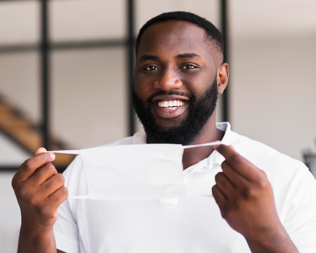 Portrait of adult male holding surgical mask