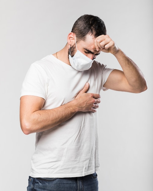portrait of adult male with face mask coughing