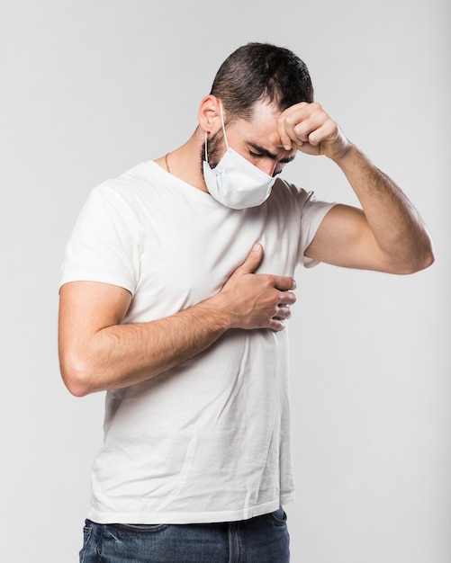 Photo portrait of adult male with face mask coughing