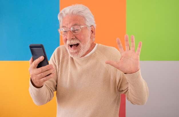 Portrait of adult senior man with shocked facial expression looking at mobile phone