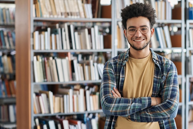 大学の図書館で腕を組んでカメラに向かって微笑む成人学生のポートレート