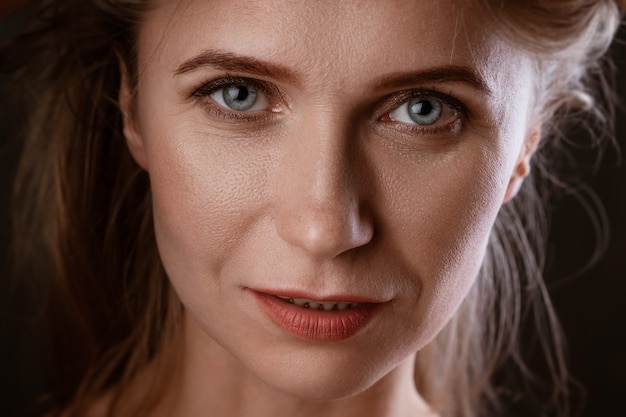 Portrait of an adult woman close-up clean skin on a dark background beautiful eyes