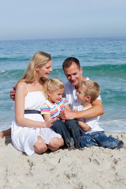 Portrait of an affectionate family sitting on the sand 