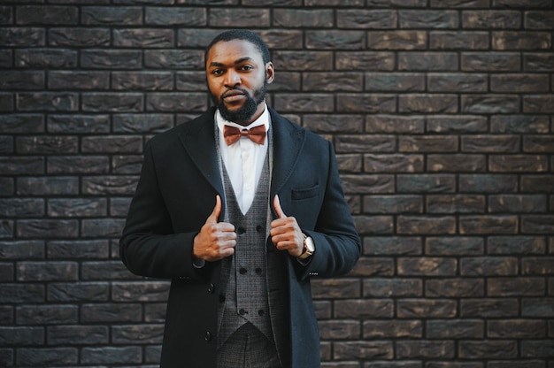 Photo portrait of an african-american businessman wearing a suit standing outdoors