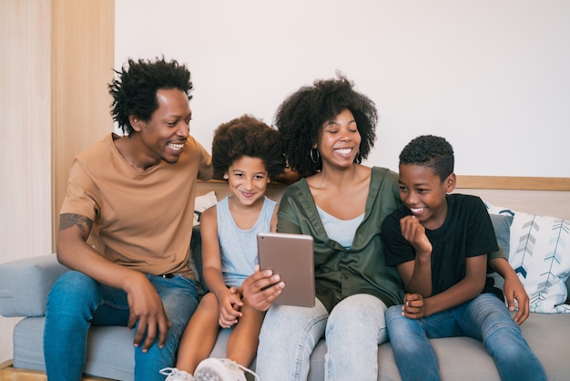 Ritratto della famiglia afroamericana che prende un selfie insieme alla tavoletta digitale a casa. concetto di famiglia e stile di vita.