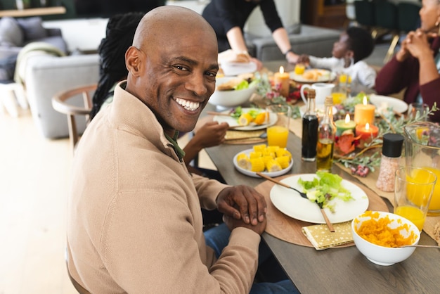Portrait of african american father with family smiling at thanksgiving dinner table