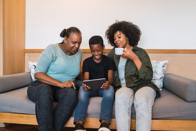 Ritratto di nonna afroamericana, madre e figlio utilizzando la tavoletta digitale a casa