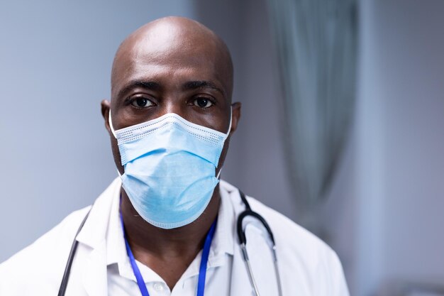 portrait of african american male doctor in hospital wearing face mask