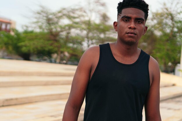 Portrait of African American man standing in city park.