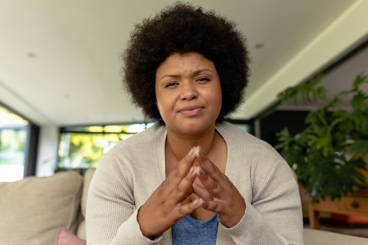 Photo portrait of african american mid adult woman gesturing during video conference at home