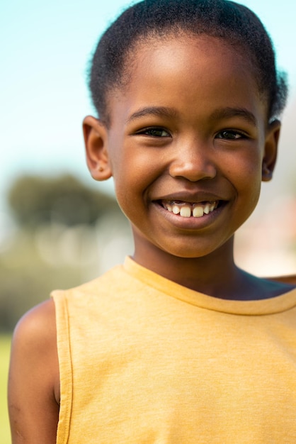 Photo portrait of african american schoolgirl smiling in sports field at elementary school