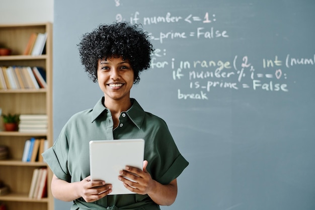 Portrait of african american teacher smiling at camera while using tablet pc at lesson