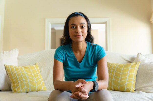 Photo portrait of african american woman sitting on the couch at home