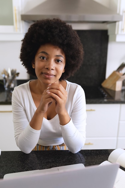 Portrait of african american woman sitting in kitchen smiling