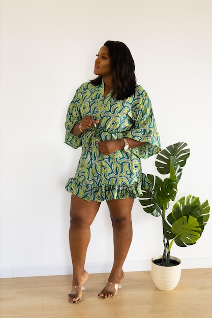 Portrait of african american woman smiling against white wall in room inclusion and diversity concept