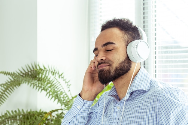 Portrait of an african american young man listening to music in headphones