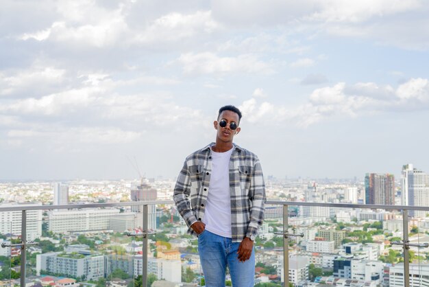 Portrait of African black man outdoors in city at rooftop during summer horizontal shot