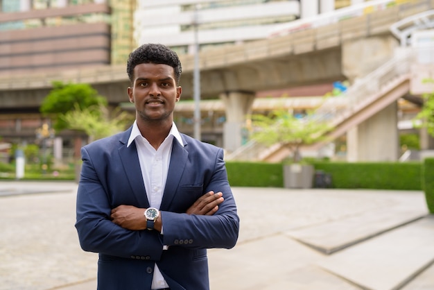 Portrait of African businessman outdoors in city, horizontal shot