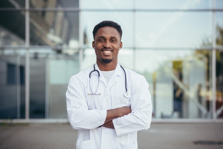 Photo portrait of an african doctor looking at camera and smiling in front of clinic
