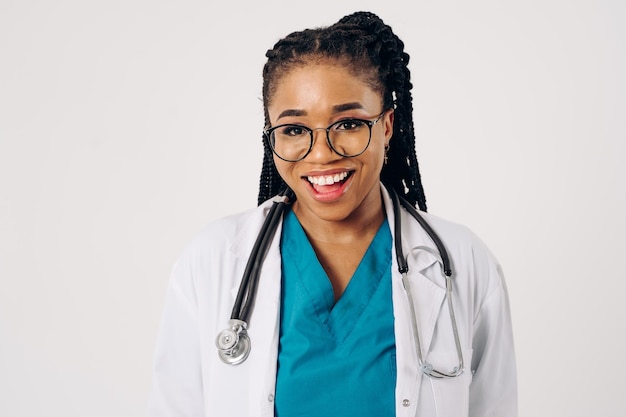 Photo portrait of african female doctor in scrub and lab coat with stethoscope against white background