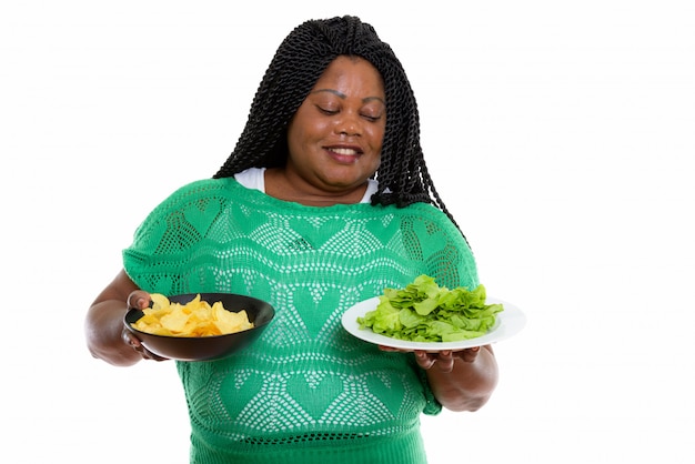 portrait of African woman holding chips and salad