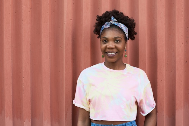 Portrait of African young girl smiling at camera while standing outdoors