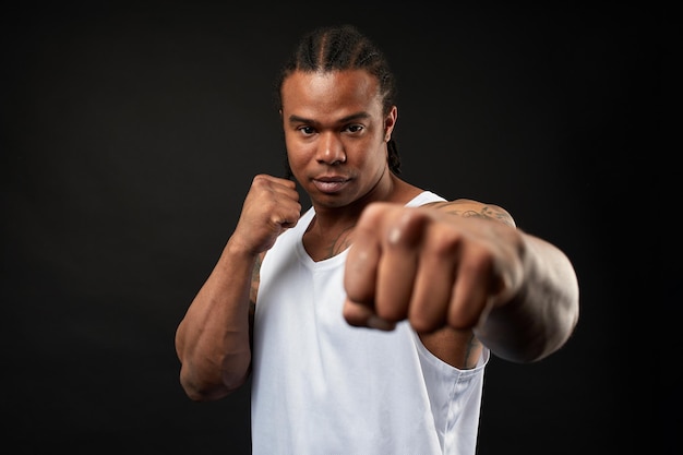 Portrait of africanamerican athlete man boxing on black background