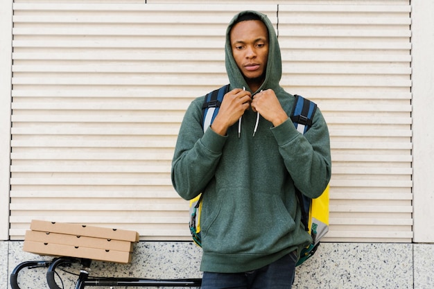 Portrait of an AfricanAmerican courier outside A delivery man on a bicycle Fast delivery from restaurants