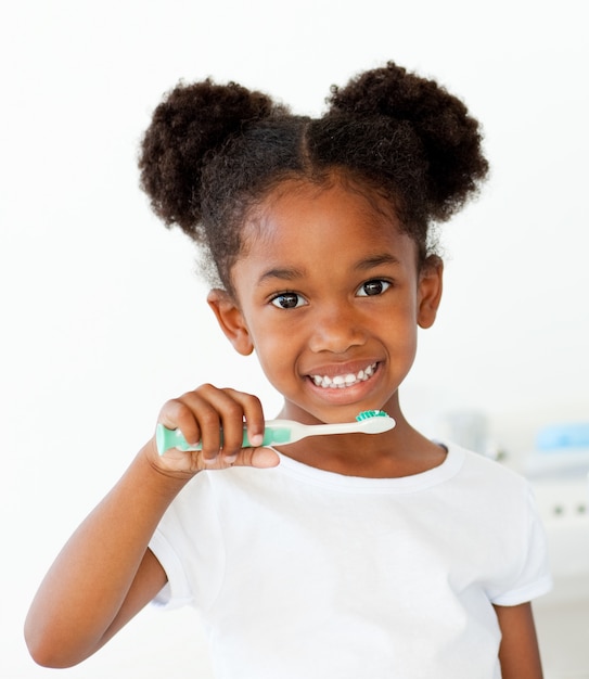 Portrait of an Afro-american girl brushing her teeth