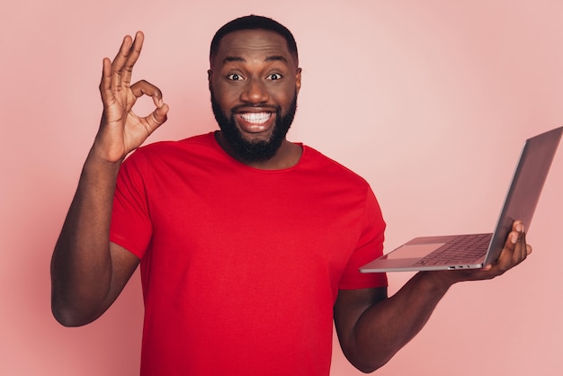 Portrait of afro american man using laptop show okey symbol