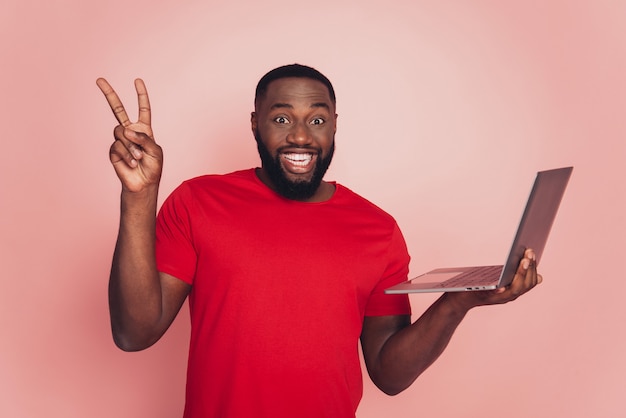 Portrait of afro american man using laptop show v-sign