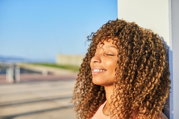 Premium Photo | Portrait of an afro american woman with curly hair and  closed eyes while smiling
