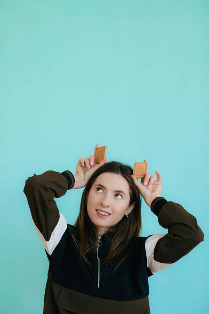 Portrait of alluring redhead woman 20s smiling and eating sweet cookies