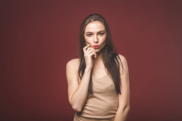 Portrait of amazed young woman isolated over red background.