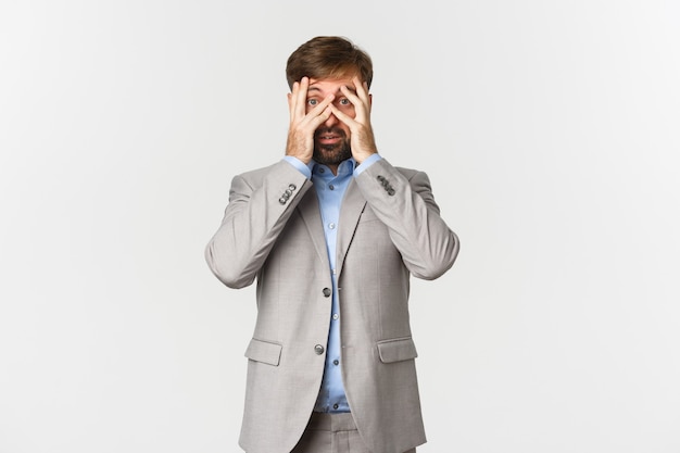 Portrait of ambushed businessman, cover eyes and peeking through fingers