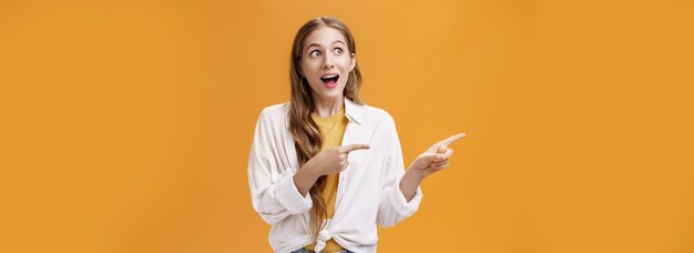 Portrait of amused and excited good-looking caucasian girl with wavy fair hairstyle in blouse over t