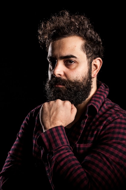 Portrait of angry bearded man on black background