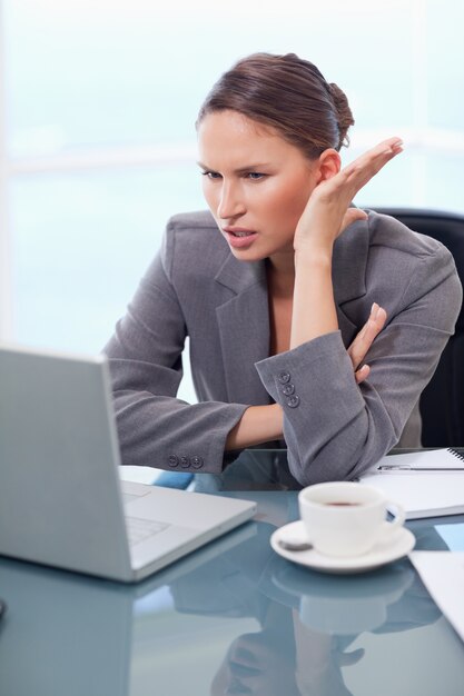 Portrait of an angry businesswoman working with a notebook