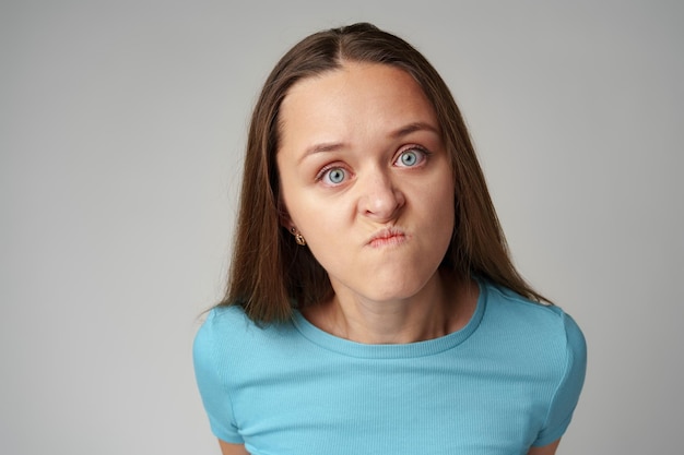 Photo portrait of angry crazy young woman on gray background