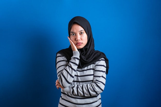 의심스러운 표정으로 카메라를 바라보는 화난 냉소적인 아시아 이슬람 여성의 초상화, 불신 개념